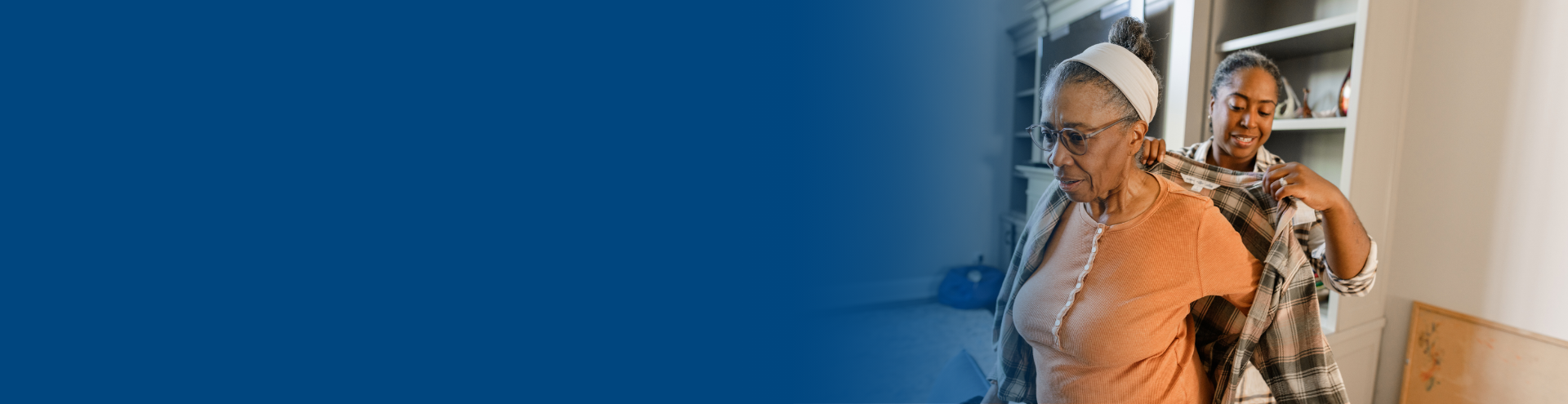 Caregiver helps older woman put on her jacket